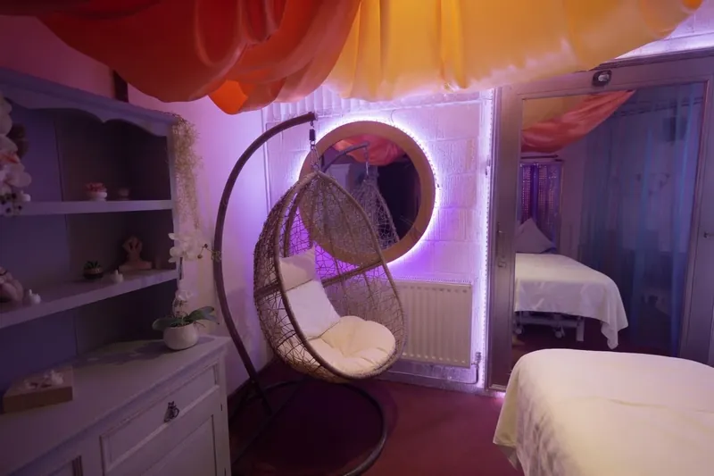 The white tantric room at The Workshop, with a hanging chair and round mirror
